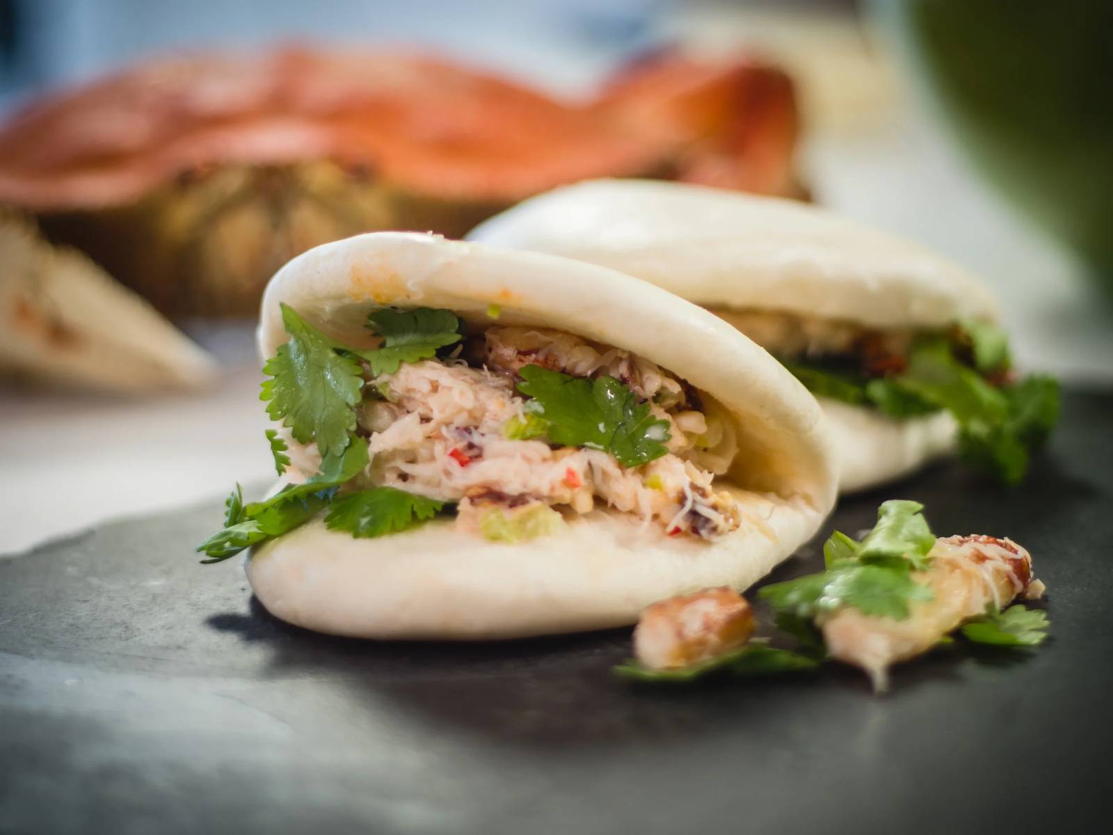 Steamed bao buns filled with shredded blue crab and herbs