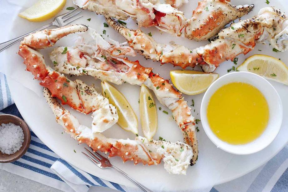 Split king crab legs served with lemon and a bowl of drawn butter