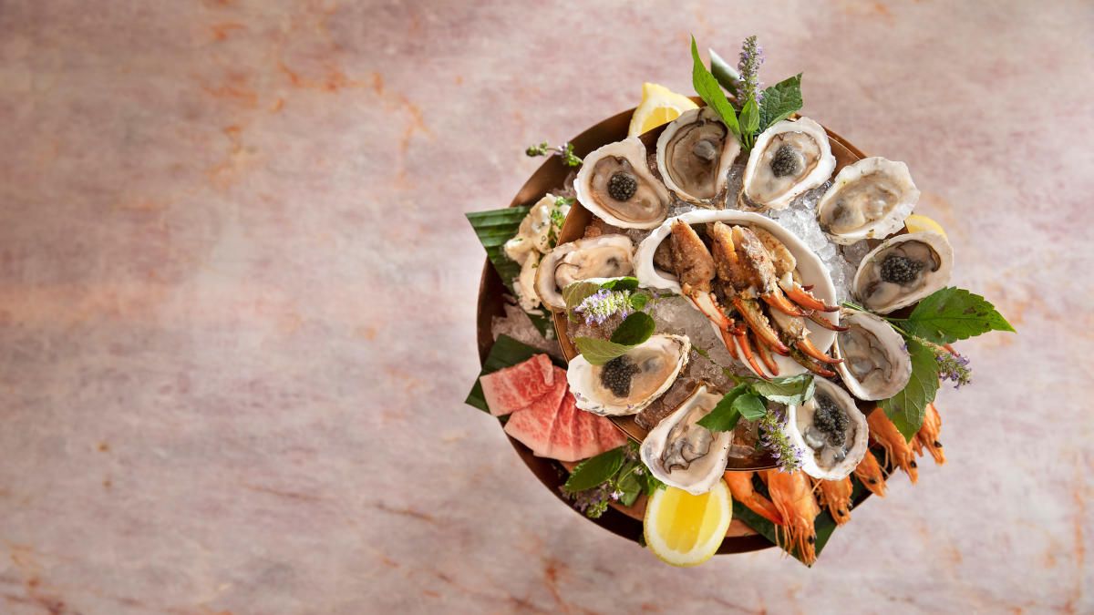 Chilled seafood tower with crab and oysters as a hero backdrop