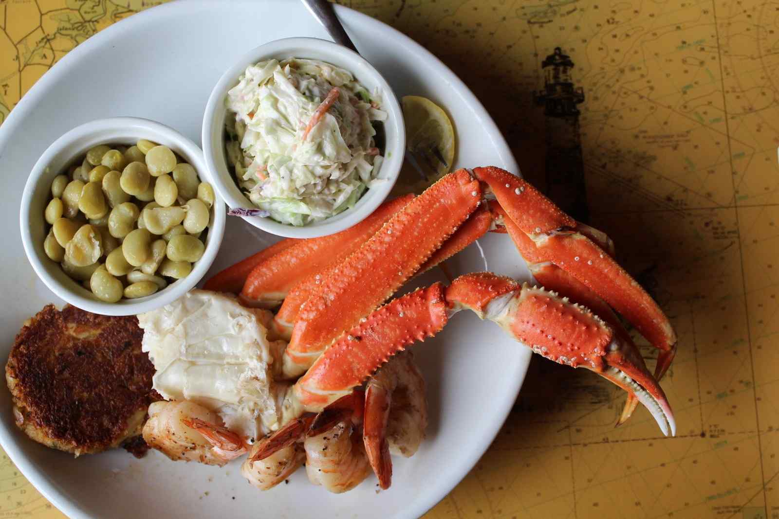 Snow crab cluster served with coleslaw and olives on a plate